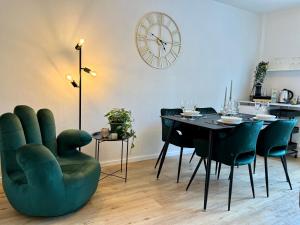 een eetkamer met een tafel en stoelen en een klok bij Design Apartment mit Balkon - Küche - Netflix in Essen