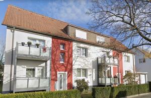 een wit en rood huis met een rood dak bij Design Apartment mit Balkon - Küche - Netflix in Essen