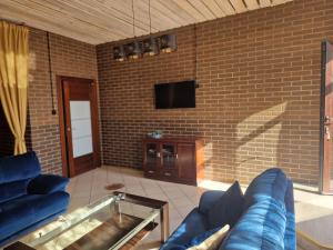 a living room with a blue couch and a tv at WILLA VASCO ADMIRAŁ in Rewa
