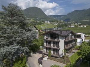 una vista aérea de una casa con montañas en el fondo en Meran Suites Nice Five Two, en Merano