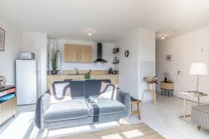 a living room with a couch and a kitchen at Le May'Aïta - Calme, Parking & Central in Anglet