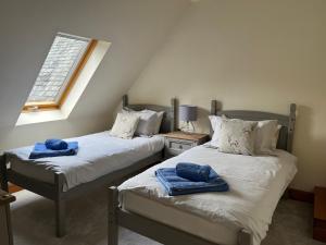 two twin beds in a room with a window at Lairds and Keepers Apartments in Dunkeld