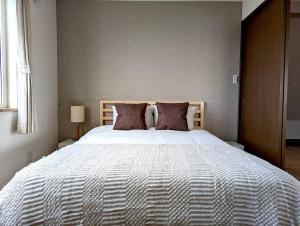 ein Schlafzimmer mit einem großen weißen Bett mit Kissen in der Unterkunft Beach Front Fugoppe - spacious & sunny in Yoichi