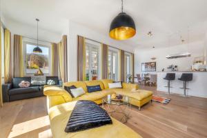 ein großes Wohnzimmer mit einem gelben Sofa und einem Wohnzimmer in der Unterkunft FIRST Avalon in Ostseebad Sellin
