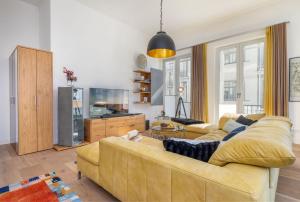 ein Wohnzimmer mit einem gelben Sofa und einem TV in der Unterkunft FIRST Avalon in Ostseebad Sellin + 23 Fotos