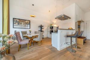 eine Küche und ein Esszimmer mit Tisch und Stühlen in der Unterkunft FIRST Avalon in Ostseebad Sellin