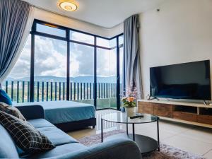 een woonkamer met een blauwe bank en een tv bij Beacon Executive Suite by NGN - Georgetown Penang in George Town