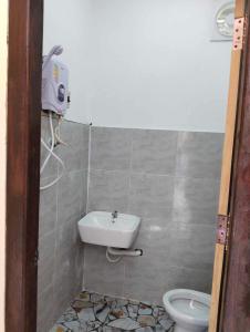 a bathroom with a sink and a toilet at Dorm Riverside in Pakbeng