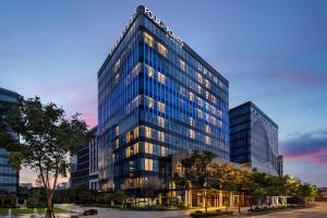 a tall building with lights on in a city at Four Points by Sheraton Shanghai Hongqiao in Shanghai