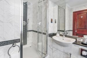 a bathroom with a sink and a glass shower at Gem Fitzrovia Hotel in London