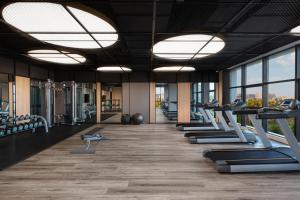 a gym with a row of treadmills and ellipticals at Four Points by Sheraton Shanghai Hongqiao in Shanghai