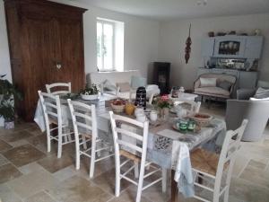a dining room with a table with white chairs at Chambre d hotes la Barrière in Channay-sur-Lathan