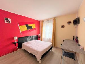 a bedroom with a white bed and a red wall at Hôtel Les Jardins Dunkerque centre in Dunkerque