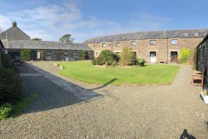 an estate with a large yard in front of a building at The Stables - Crackington Haven Cornwall in Crackington Haven