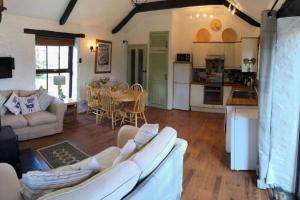 a living room with a couch and a table and a kitchen at The Stables - Crackington Haven Cornwall in Crackington Haven
