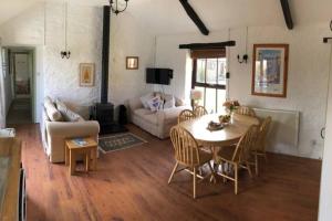 a living room with a table and a couch at The Stables - Crackington Haven Cornwall in Crackington Haven