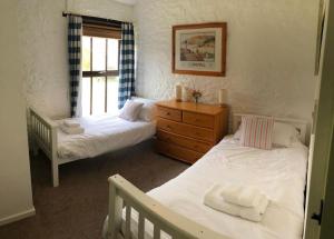 a bedroom with two beds and a window at The Stables - Crackington Haven Cornwall in Crackington Haven