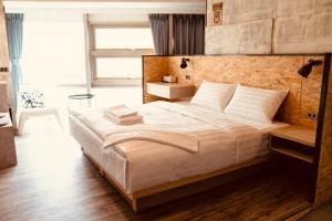 a bedroom with a large bed with a wooden headboard at Tainanwow in Tainan