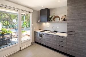 a kitchen with a sink and a sliding glass door at Waterman Beach Village in Supetar