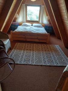 a bedroom with a bed with a window and a rug at Haus am See Willingen in Willingen