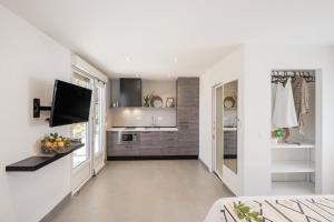 a kitchen with white walls and a flat screen tv at Waterman Beach Village in Supetar