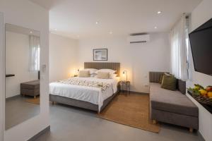 1 dormitorio con 1 cama y 1 sofá en Waterman Beach Village en Supetar