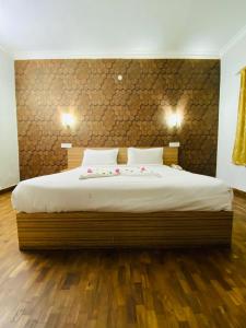 a bedroom with a large bed with a wooden floor at Tulips Resorts - Elkhill in Ooty