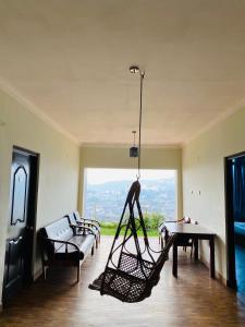 a living room with a hammock and a couch and a table at Tulips Resorts - Elkhill in Ooty