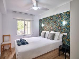 a bedroom with a large white bed with a painting on the wall at NEW Plaza Elíptica Metro Bus 15 min centro 3d Luxe reformado in Madrid