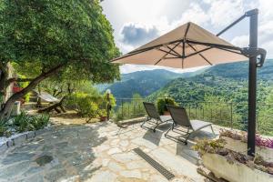 a patio with two chairs and an umbrella at Belvedere, House With Pool- Recco, Liguria 