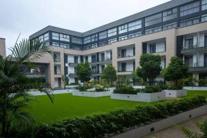 a large building with a green lawn in front of it at Family 3 Bed Loft @Cantonments in Cantonments