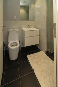 a bathroom with a toilet and a sink at Family 3 Bed Loft @Cantonments in Cantonments