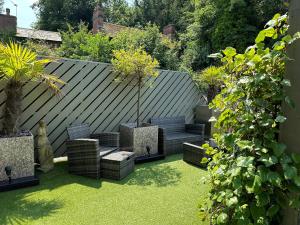 een tuin met stoelen en planten op het gras bij The Charlton Arms in Ludlow