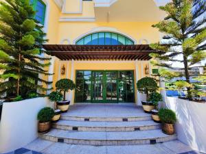 a building with stairs and palm trees in front of it at Siri Grand Bangkok Hotel in Bangkok