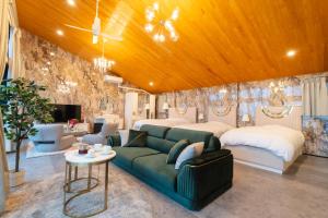 野間にあるGlamping＆Resort WOOD DESIGN PARK NOMAのベッドルーム(緑のソファ、ベッド2台付)