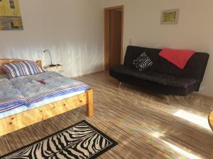 ein Schlafzimmer mit einem Bett und einem Sofa in der Unterkunft Ferienwohnungen Seestraße in Sassnitz