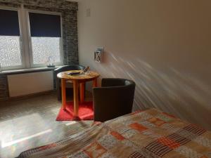 Zimmer mit einem Tisch, einem Stuhl und 2 Fenstern in der Unterkunft Ferienwohnungen Seestraße in Sassnitz
