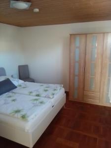 ザスニッツにあるFerienwohnung Straßburgのベッドルーム1室(ベッド1台付)、木製キャビネットが備わります。