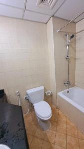 a bathroom with a toilet and a bath tub at Studio flat DG079, Close to The Gardens Metro 3 min walkable in Dubai