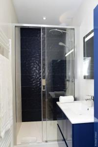 een badkamer met een glazen douche en een wastafel bij La Chouette in Dijon +16 foto's