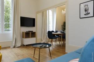 a living room with a blue couch and a table at La Chouette in Dijon