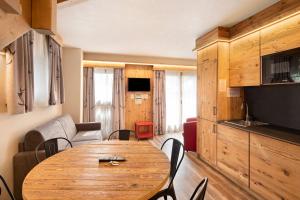 Il comprend un salon avec une table en bois et une cuisine. dans l'établissement Chalet Leur Gusja Golp Trilocale, à Livigno