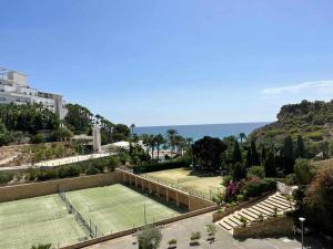 a tennis court with a tennis court at Perfecto Apartamento para vacaciones frente al mar in Villajoyosa