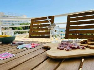 a wooden table with meat on a cutting board at Perfecto Apartamento para vacaciones frente al mar in Villajoyosa
