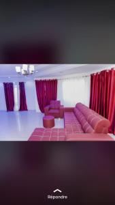 salon z kanapą i czerwonymi zasłonami w obiekcie Hôtel Ami Bamba w mieście Mbour