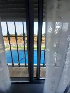 een raam met uitzicht op een zwembad bij Casa Albahacar 