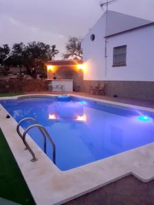 een groot zwembad met blauwe verlichting voor een gebouw bij Casa Albahacar 