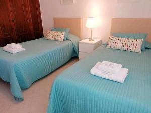 ein Schlafzimmer mit 2 Betten und Handtüchern darauf in der Unterkunft Quarteira Mar by FHR 5m da Praia in Quarteira