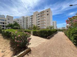 クアルテイラにあるQuarteira Mar by FHR 5m da Praiaの茂みと花の咲く建物前の通路