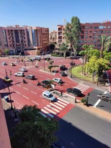 a parking lot with cars parked in a city at Hotel El Hadna By HMS in Marrakesh